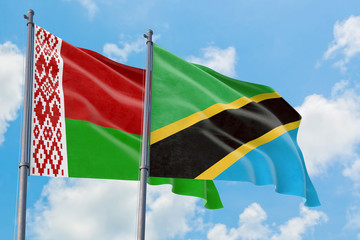 Tanzania and Belarus flags waving in the wind against white cloudy blue sky together. Diplomacy concept, international relations.