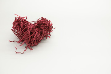Naklejka premium Red heart made of shredded paper for gift box on a light background for postcards and congratulations
