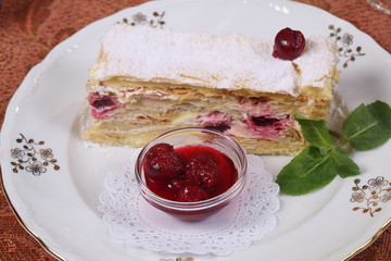 Tea with jam and cake from puff pastry with cherry