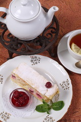 Tea with jam and cake from puff pastry with cherry