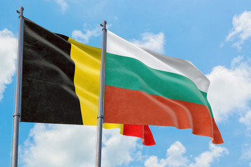 Bulgaria and Belgium flags waving in the wind against white cloudy blue sky together. Diplomacy concept, international relations.