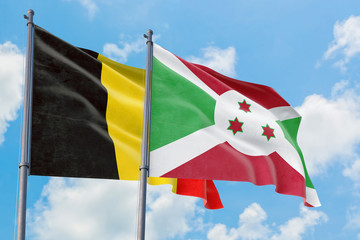 Burundi and Belgium flags waving in the wind against white cloudy blue sky together. Diplomacy concept, international relations.