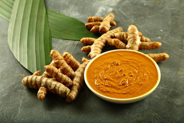 Bowl of fresh turmeric paste, cream for skin care.