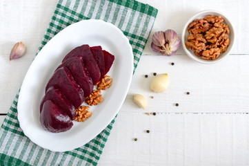 Slices of boiled beets on a white plate. Source of energy. Dietary healthy vegetable. Top view.