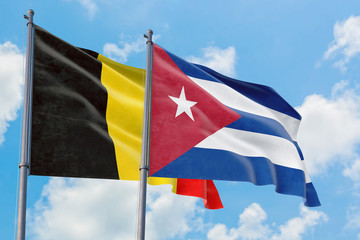 Cuba and Belgium flags waving in the wind against white cloudy blue sky together. Diplomacy concept, international relations.