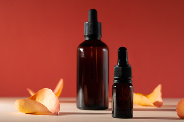 Cosmetic bottles with rose petals, copy space