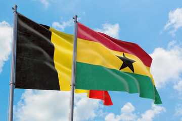 Ghana and Belgium flags waving in the wind against white cloudy blue sky together. Diplomacy concept, international relations.