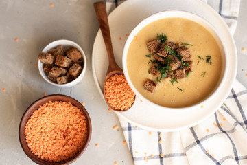 Tomato soup in a black bowl on grey stone background. Top view. Copy space.