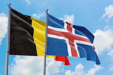 Iceland and Belgium flags waving in the wind against white cloudy blue sky together. Diplomacy concept, international relations.