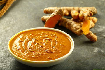 Bowl of organic turmeric root paste 