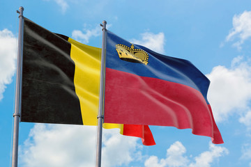 Liechtenstein and Belgium flags waving in the wind against white cloudy blue sky together. Diplomacy concept, international relations.