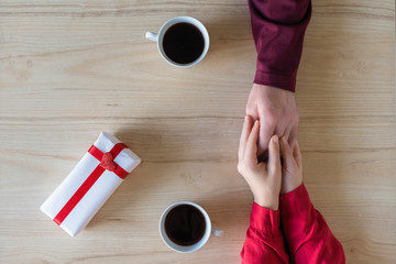 Valentines day.  Close-up of woman and man celebrating in restaurant. Boyfriend giving small box gift to girlfriend. love, romance, date. Flat lay