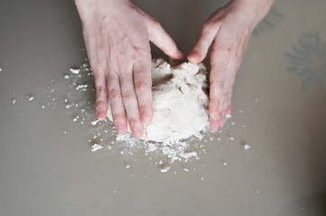 Hands wrinkle the dough close-up. Manual dough preparation. Homemade baking.