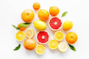 Fresh citrus background. Oranges, grapefruits, leaves - whole fruits and halfs - on white...