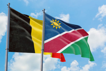 Namibia and Belgium flags waving in the wind against white cloudy blue sky together. Diplomacy concept, international relations.