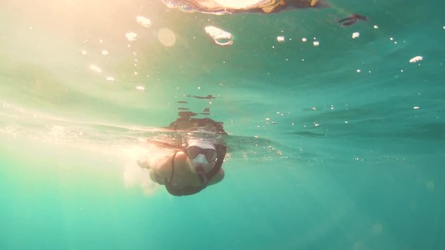 Beautiful Young Woman Snorkeling in the Sea. Girl Swimming at Sunset Underwater, Slow Motion 60 fps 4k UHD. Sun Light in Water 