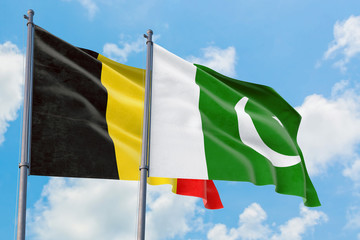 Pakistan and Belgium flags waving in the wind against white cloudy blue sky together. Diplomacy concept, international relations.