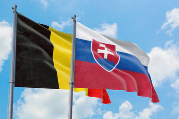 Slovakia and Belgium flags waving in the wind against white cloudy blue sky together. Diplomacy concept, international relations.