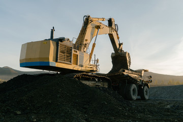 Excavator loads ore into a mining dump truck.