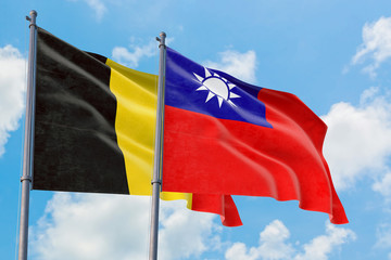 Taiwan and Belgium flags waving in the wind against white cloudy blue sky together. Diplomacy concept, international relations.