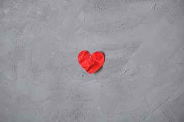 crumpled paper heart on the concrete floor.  Broken relationships in bad Valentine's day. concept.