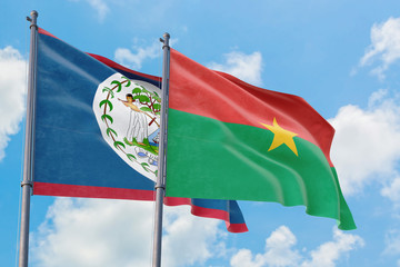 Fototapeta na wymiar Burkina Faso and Belize flags waving in the wind against white cloudy blue sky together. Diplomacy concept, international relations.