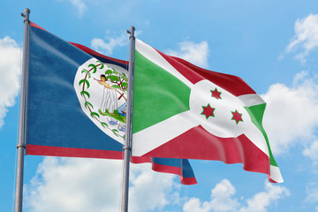 Burundi and Belize flags waving in the wind against white cloudy blue sky together. Diplomacy concept, international relations.