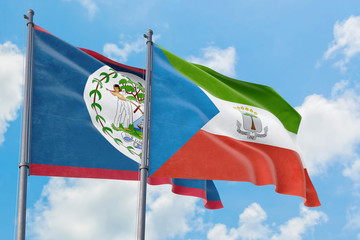 Equatorial Guinea and Belize flags waving in the wind against white cloudy blue sky together. Diplomacy concept, international relations.