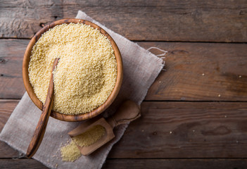 Couscous grain in wooden bowl. Top view