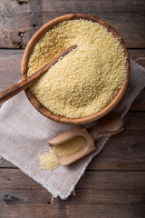 Couscous grain in wooden bowl. Selective focus