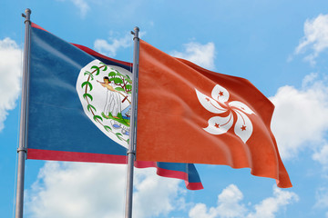 Hong Kong and Belize flags waving in the wind against white cloudy blue sky together. Diplomacy concept, international relations.