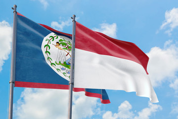 Fototapeta na wymiar Indonesia and Belize flags waving in the wind against white cloudy blue sky together. Diplomacy concept, international relations.