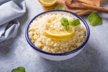 Couscous with mint and lemon in plate on dark rustic table from above. Copy space for text. Flat lay.