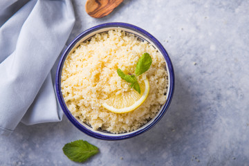 Couscous with mint and lemon in plate on dark rustic table from above. Copy space for text. Flat lay.