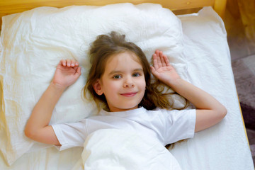 Baby a little girl is sleeping in a crib with a toy Teddy bear. Daily routine of the child. Early rise. Great mood in the morning.