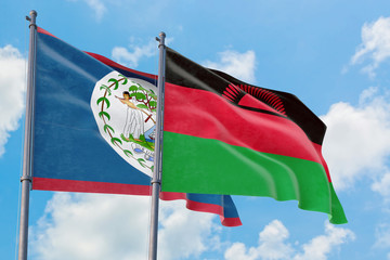 Malawi and Belize flags waving in the wind against white cloudy blue sky together. Diplomacy concept, international relations.