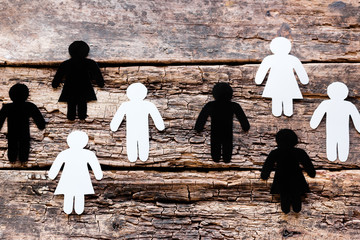 groups of white and black silhouettes on wooden background anti racism concept