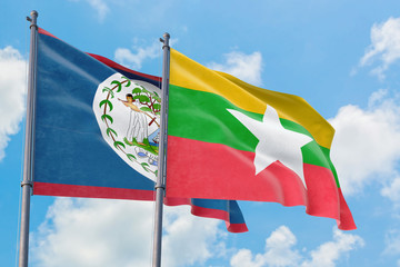 Myanmar and Belize flags waving in the wind against white cloudy blue sky together. Diplomacy concept, international relations.