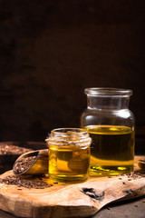 Flax seeds oil and raw seeds on wooden background.