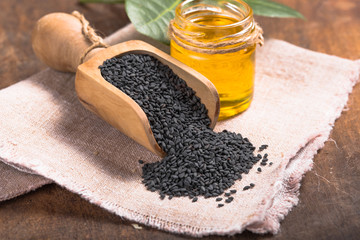 black sesame and oil on old wooden background