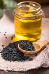 black sesame and oil on old wooden background