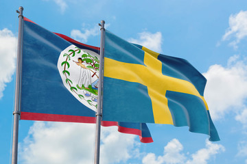 Sweden and Belize flags waving in the wind against white cloudy blue sky together. Diplomacy...