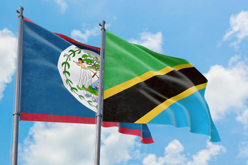 Tanzania and Belize flags waving in the wind against white cloudy blue sky together. Diplomacy concept, international relations.