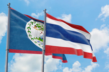 Thailand and Belize flags waving in the wind against white cloudy blue sky together. Diplomacy concept, international relations.
