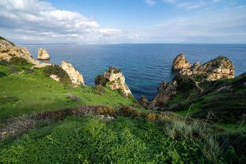 Fototapeta na wymiar Scenic natural cliff formations of Algarve coastline with green grass at Ponta da Piedade, in Algarve Portugal