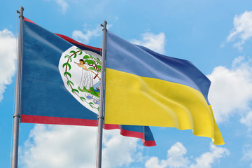 Ukraine and Belize flags waving in the wind against white cloudy blue sky together. Diplomacy concept, international relations.