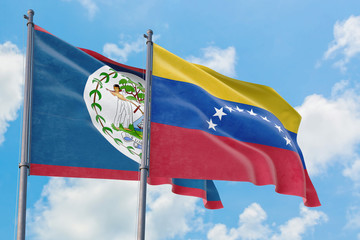 Venezuela and Belize flags waving in the wind against white cloudy blue sky together. Diplomacy concept, international relations.