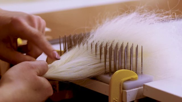 Hair combing when creating a wig. Factory wig production process