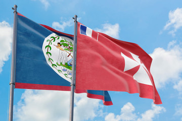 Wallis And Futuna and Belize flags waving in the wind against white cloudy blue sky together. Diplomacy concept, international relations.