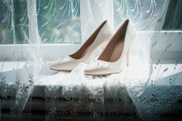 Pair of wedding high heel shoes on the windowsill